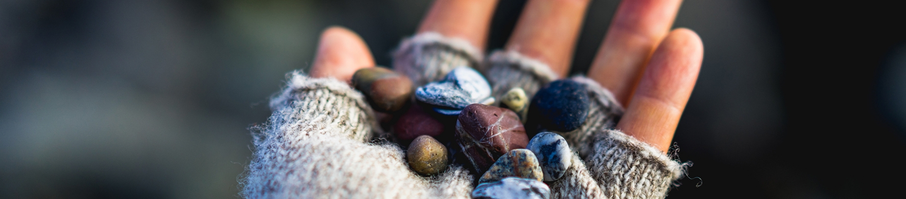 A person's hand holding small pebbles A person's hand holding small pebbles