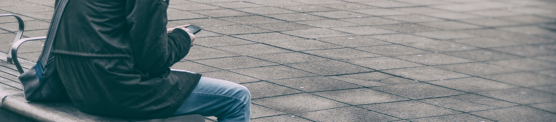 A guy sat on a bench looking at his phone A guy sat on a bench looking at his phone
