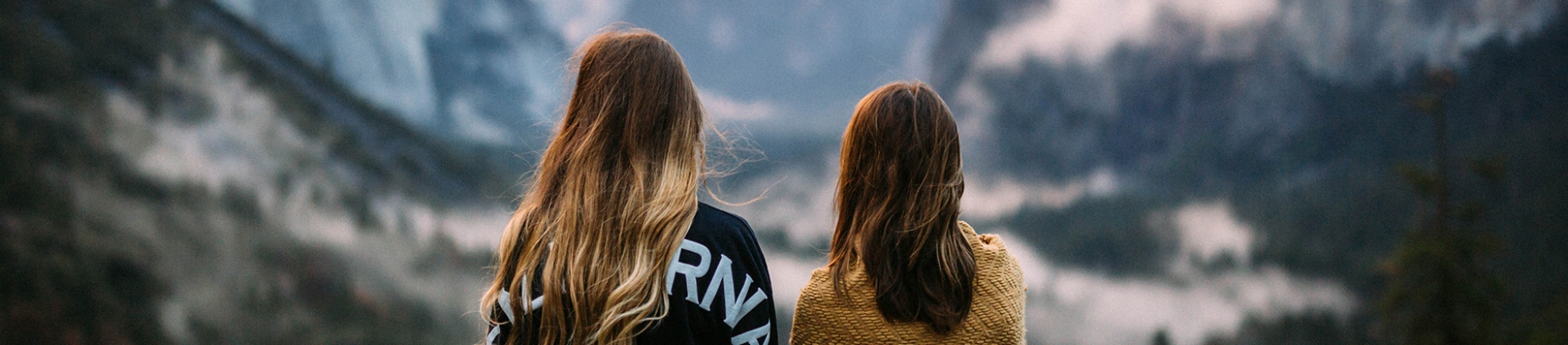 Two girls looking out over a mountain range