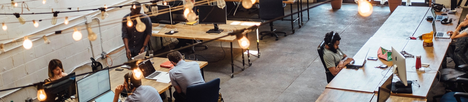 A rustic office with people sat around desks A rustic office with people sat around desks
