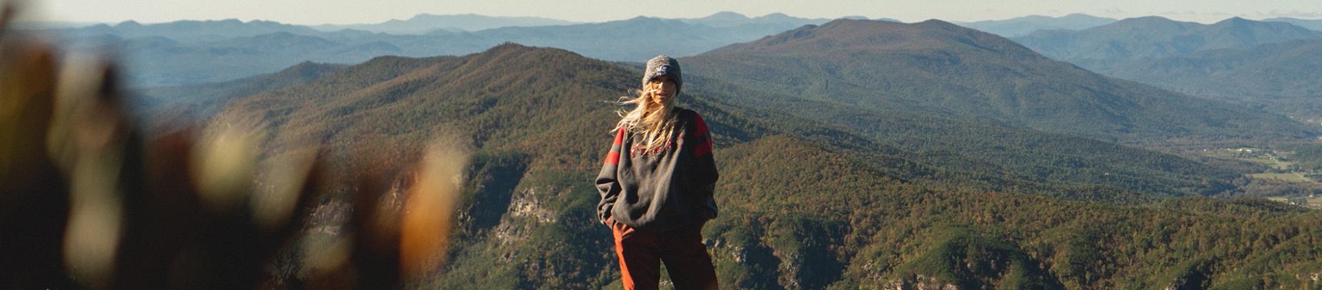 A women stood on top of a mountain with her hair blowing in the wind A women stood on top of a mountain with her hair blowing in the wind