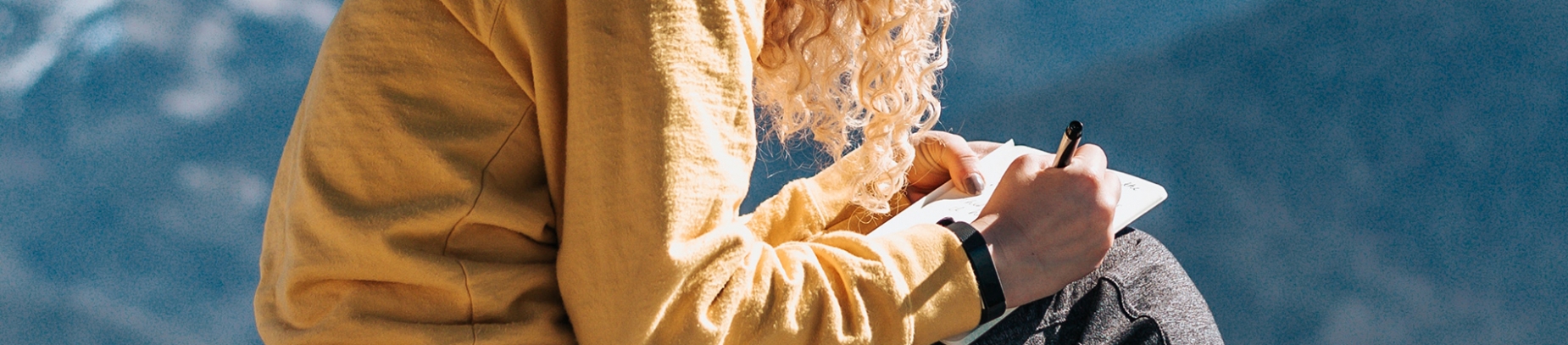 A women sat writing in a notebook A women sat writing in a notebook