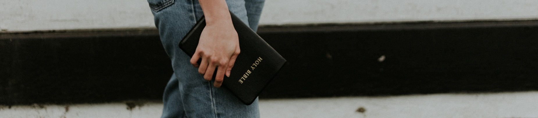 A women holding a bible down by her side A women holding a bible down by her side
