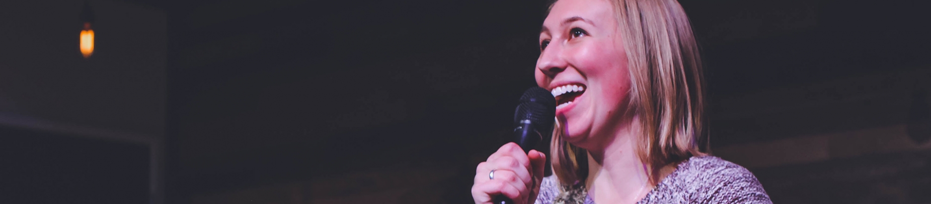 A women smiling and speaking into a microphone A women smiling and speaking into a microphone