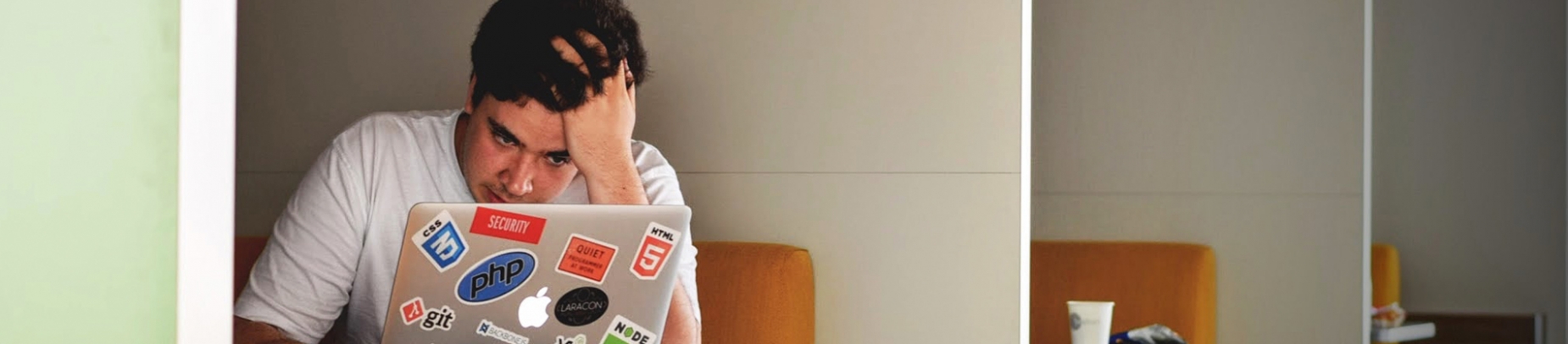 A man sat on his laptop with his head in his hand A man sat on his laptop with his head in his hand