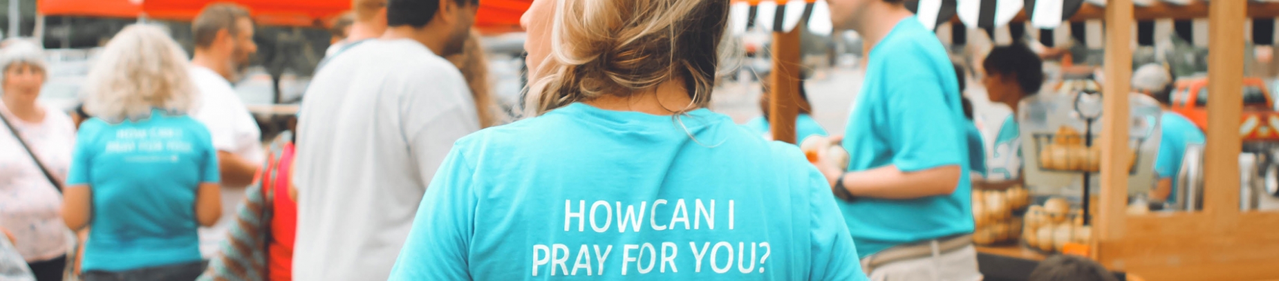 A woman in a blue prayer team t-shirt volunteering at a event A woman in a blue prayer team t-shirt volunteering at a event