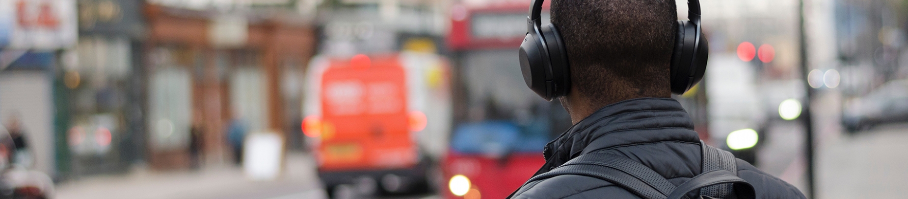 A man wearing headphones walking down a street
