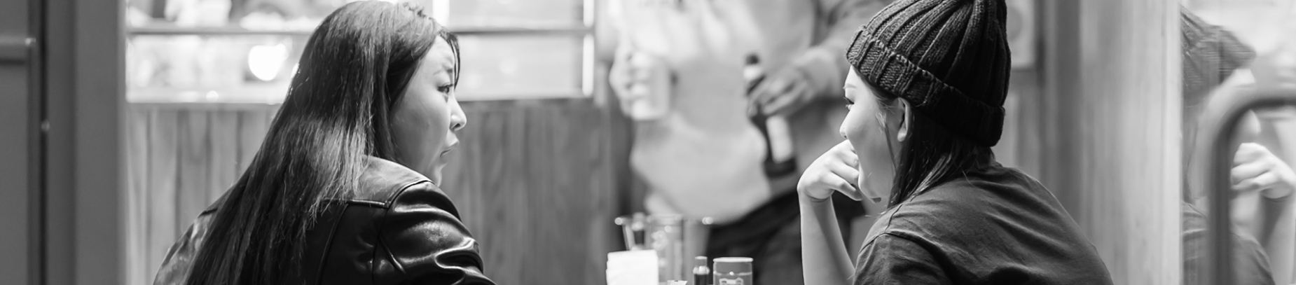 Two women in a cafe chatting across the table Two women in a cafe chatting across the table