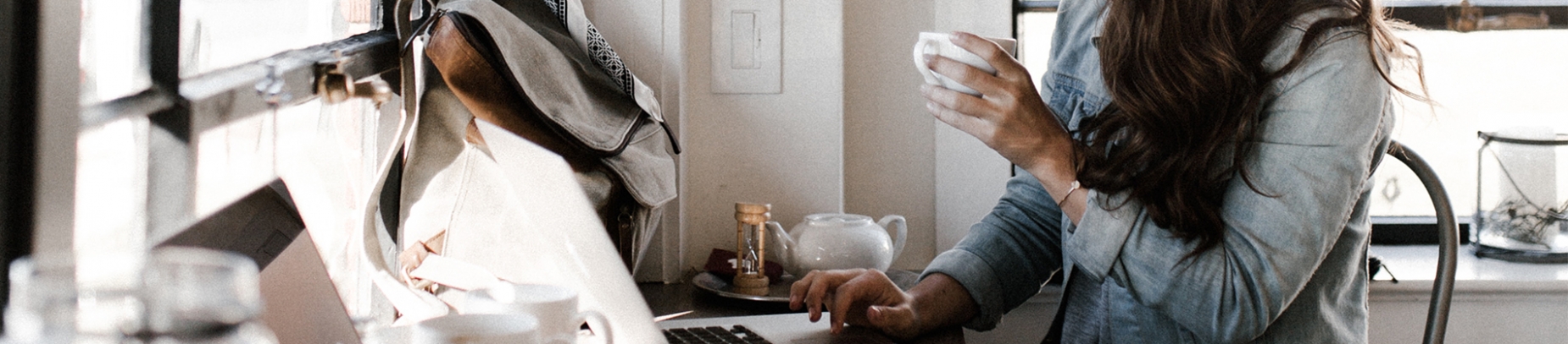 A women sat at her desk on her laptop with a cup of coffee A women sat at her desk on her laptop with a cup of coffee