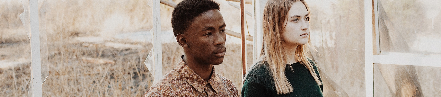 A guy and girl stood together in a broken greenhouse A guy and girl stood together in a broken greenhouse