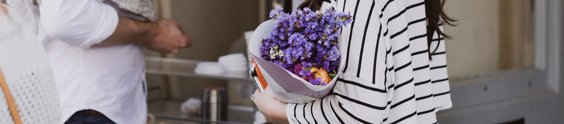 A women holding a bunch of flowers talking to a guy