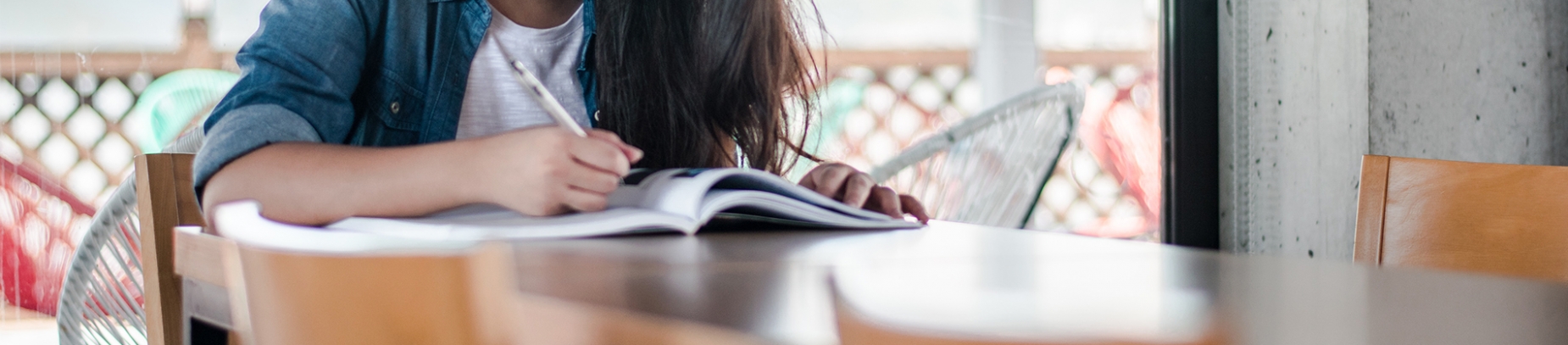 A girl working in a textbook on a table