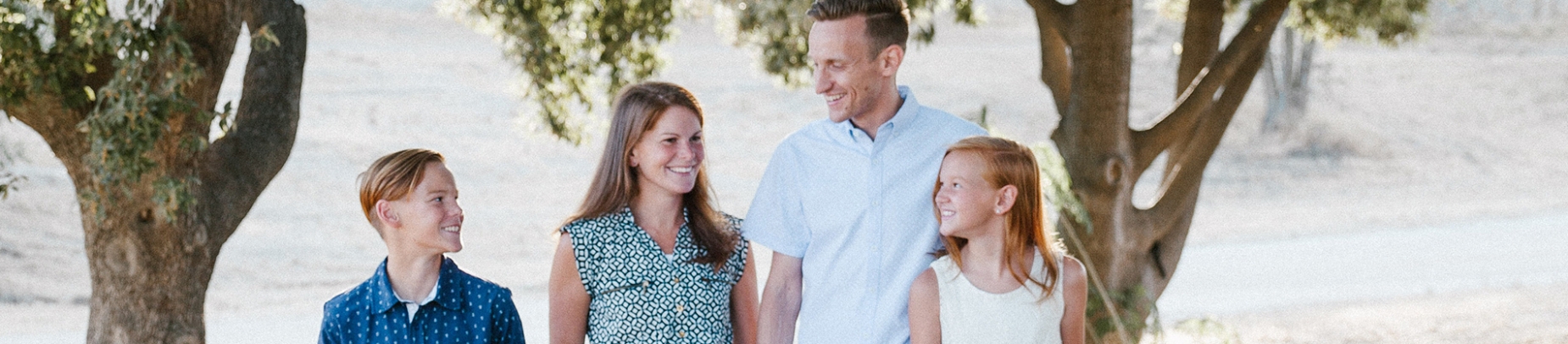 A smiling family walking through a forest A smiling family walking through a forest