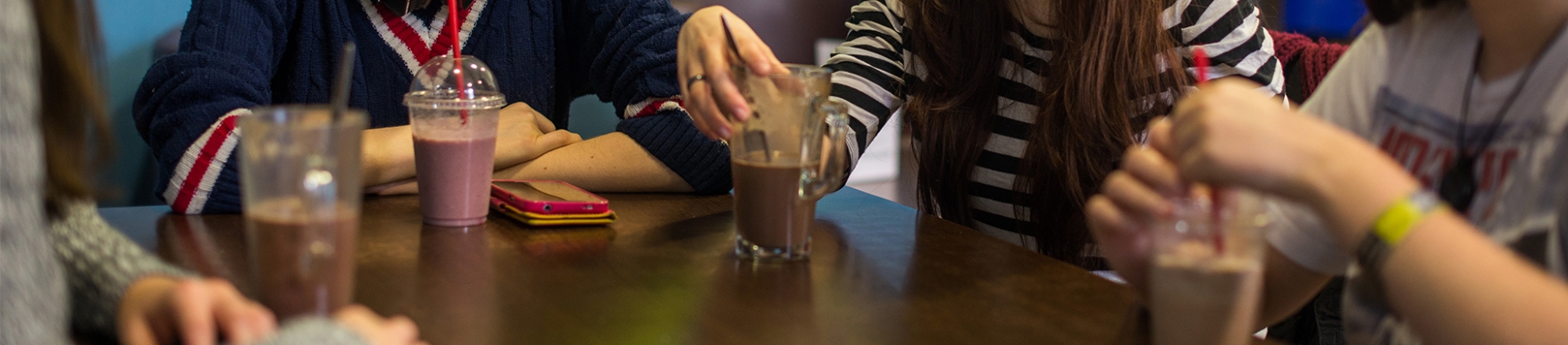 A group of girls sat around a table with drinks