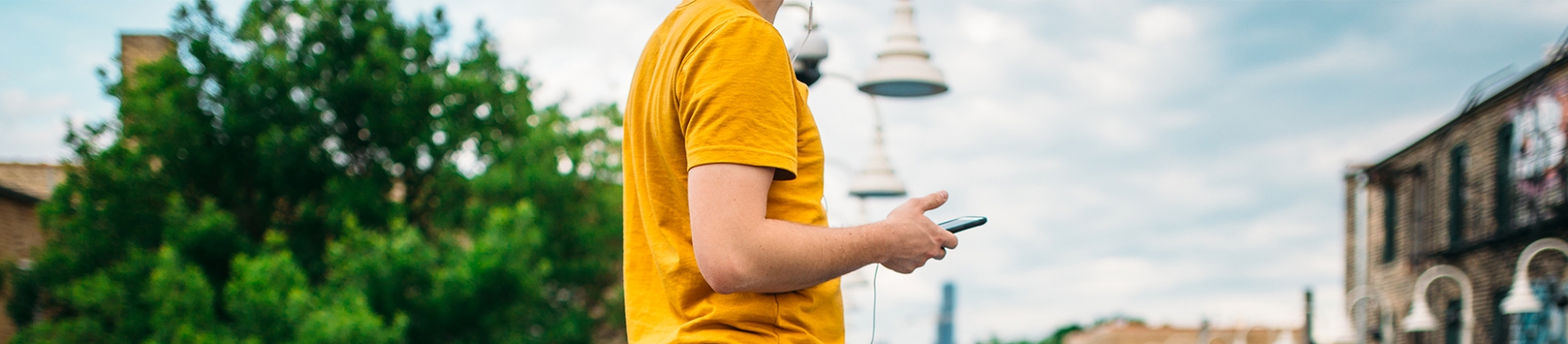 Man in a yellow t-shirt on his phone