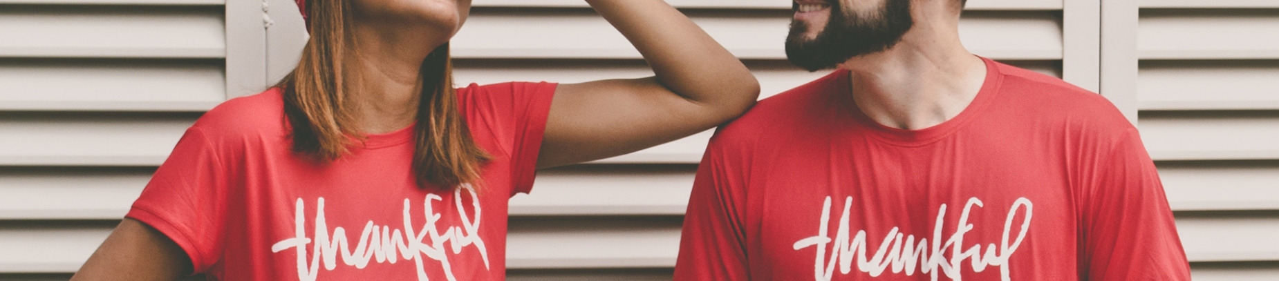 A man and a women wearing red tops with the word 'thankful' written on A man and a women wearing red tops with the word 'thankful' written on