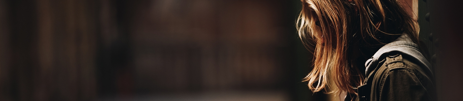 A girl leaning against a wall looking down at the ground A girl leaning against a wall looking down at the ground