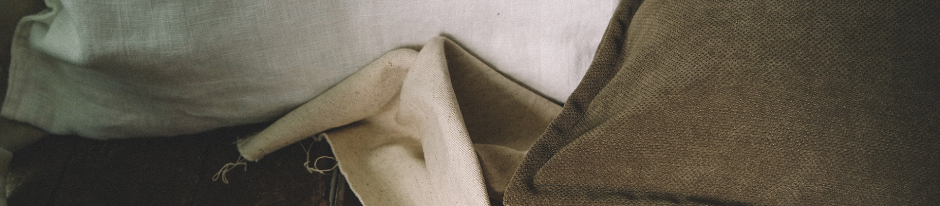 brown pillows and linen on a wooden floor