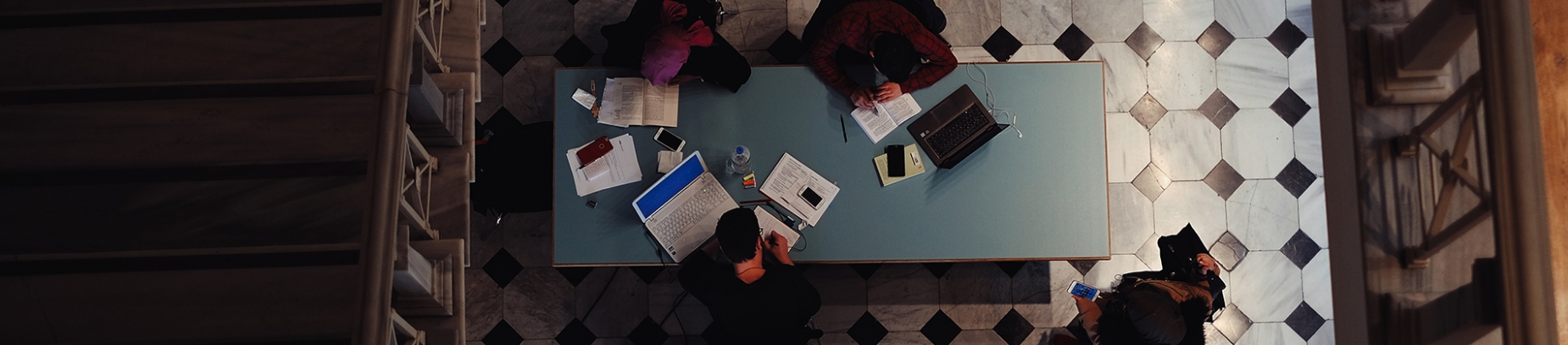 People sat around a library table working People sat around a library table working