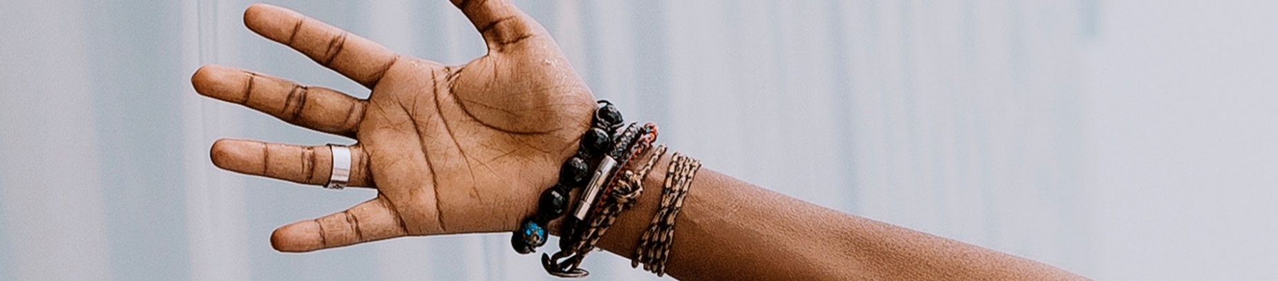 A hand reaching out with bracelets on their wrist A hand reaching out with bracelets on their wrist