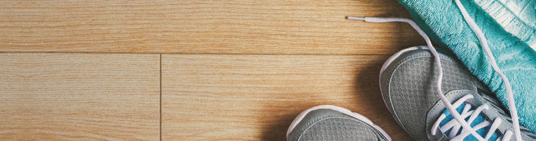 Trainers and towel on a wooden floor
